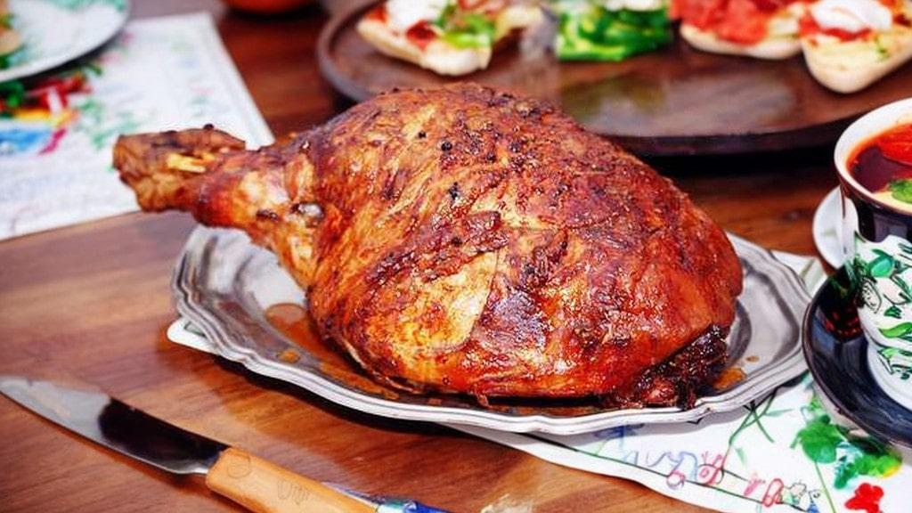 pernil de natal assado dourado e suculento decorado com frutas